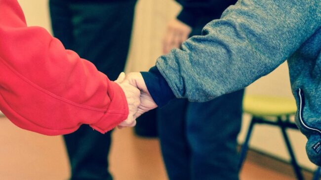 elderly holding hands e1612195698817