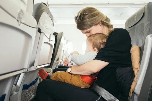 child on mothers lap on plane