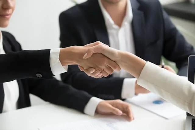 Why it’s best to reach a mutual agreement over child custody outside of the courts - couple shaking hands across a table